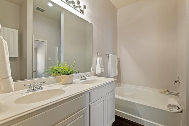 bathroom with vanity and a bath