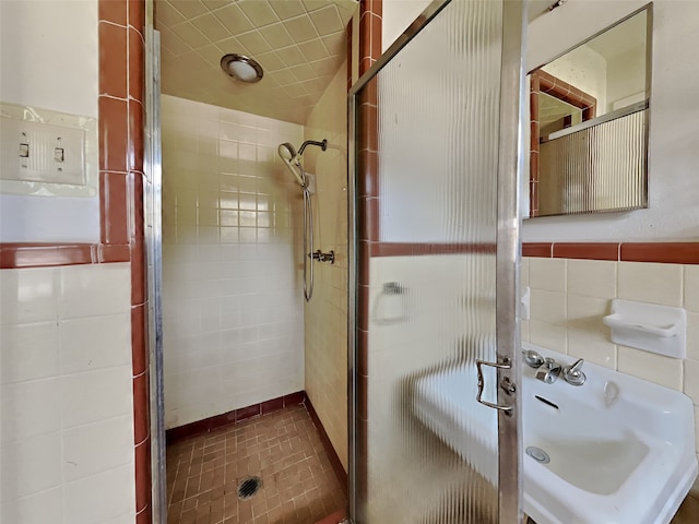 bathroom with tile walls and a shower with shower door