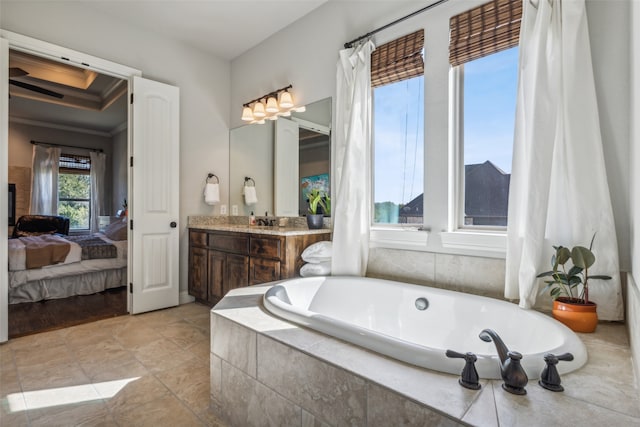 bathroom with vanity, ornamental molding, and tiled tub