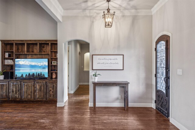 7817 Bella Flora Dr, Fort Worth, TX 76126 - entrance foyer with dark wood-style flooring, an inviting chandelier, arched walkways, baseboards, and ornamental molding