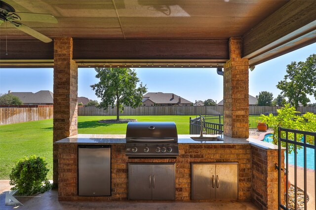 view of patio with sink, exterior kitchen, grilling area, and ceiling fan