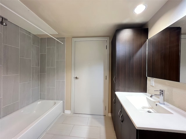 bathroom featuring vanity, tiled shower / bath combo, and tile patterned flooring