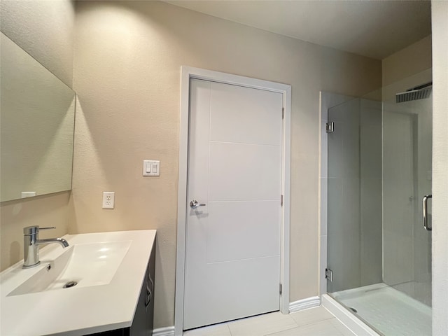 bathroom with vanity, a shower with shower door, and tile patterned flooring