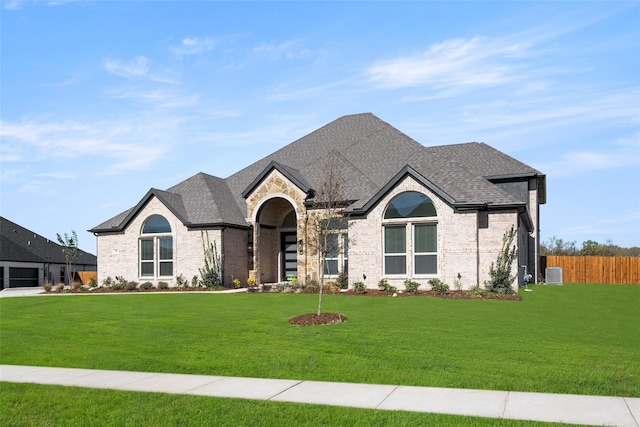 french provincial home featuring central AC and a front yard