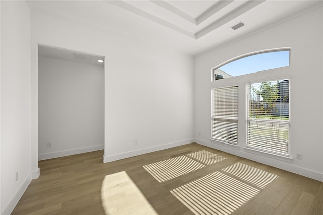 spare room featuring hardwood / wood-style flooring and ornamental molding