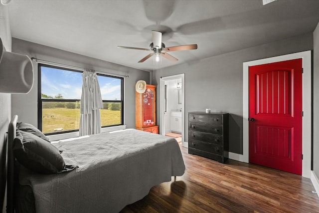 bedroom featuring dark hardwood / wood-style flooring, ensuite bath, and ceiling fan