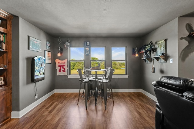 dining area with hardwood / wood-style floors and a textured ceiling