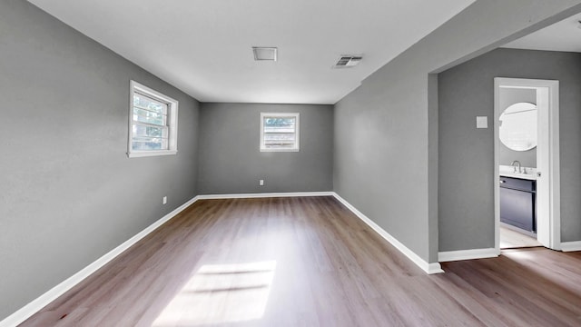 unfurnished room featuring light hardwood / wood-style floors and sink