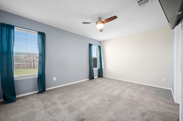 carpeted spare room featuring ceiling fan