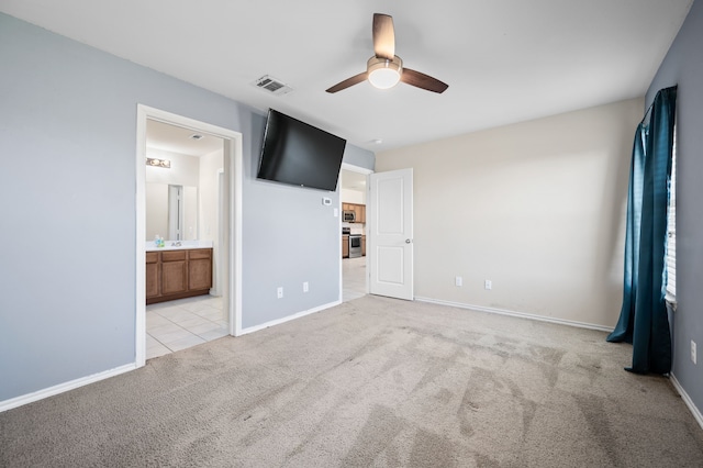 unfurnished bedroom with light carpet, ensuite bath, and ceiling fan