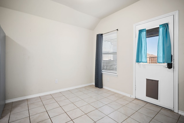 tiled empty room featuring lofted ceiling and a healthy amount of sunlight