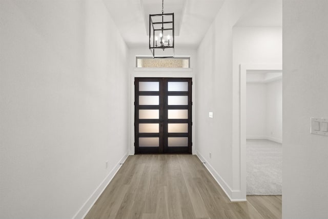 foyer with an inviting chandelier and light hardwood / wood-style flooring