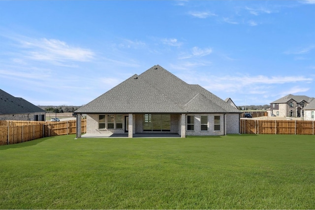 rear view of house with a lawn and a patio