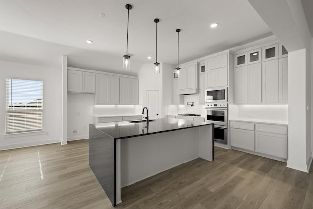 kitchen featuring sink, appliances with stainless steel finishes, an island with sink, and white cabinetry