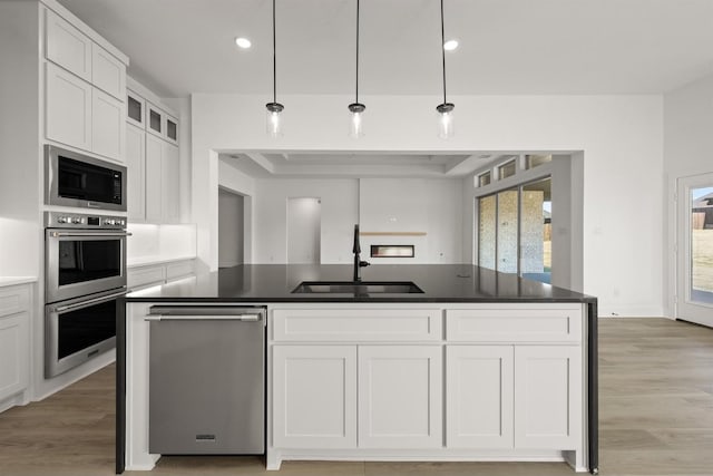 kitchen featuring plenty of natural light, sink, white cabinetry, and pendant lighting