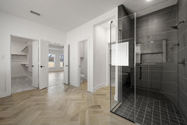 bathroom featuring toilet and an enclosed shower