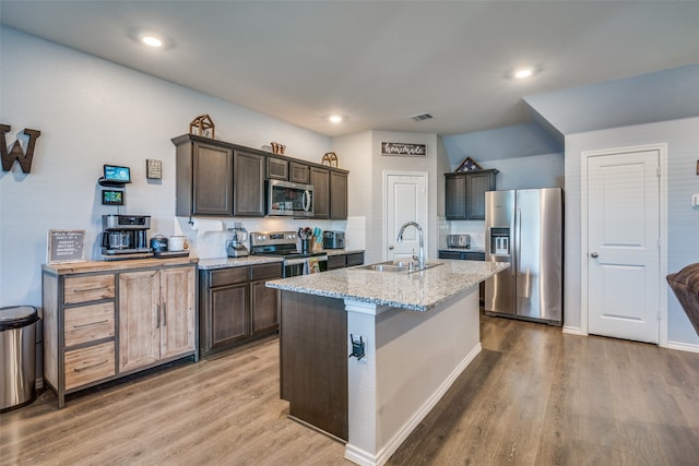 kitchen with stainless steel appliances, a center island with sink, light hardwood / wood-style floors, and sink