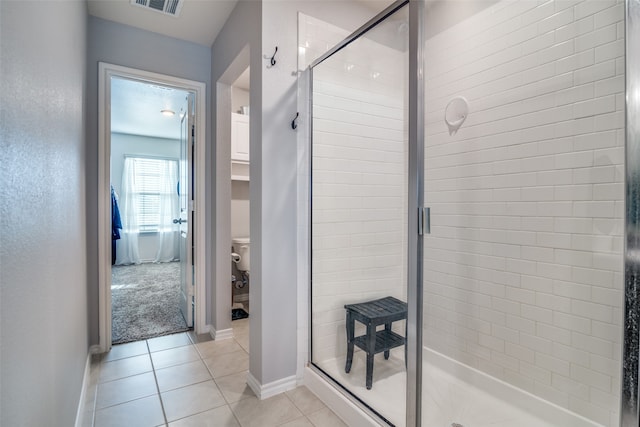 bathroom featuring tile patterned floors, an enclosed shower, and toilet