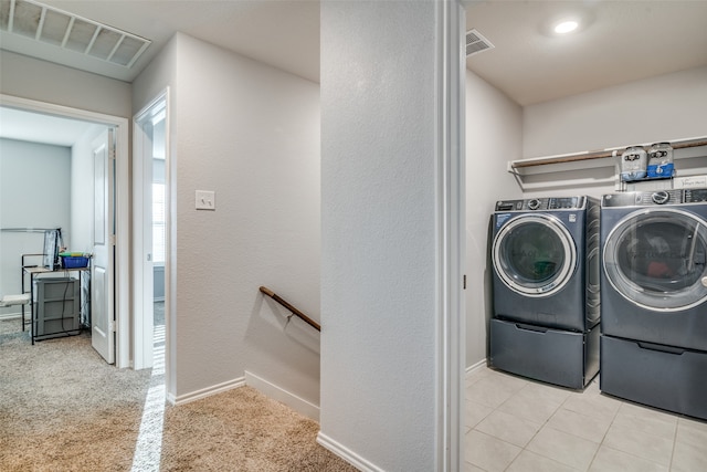 laundry area with washer and dryer and light carpet