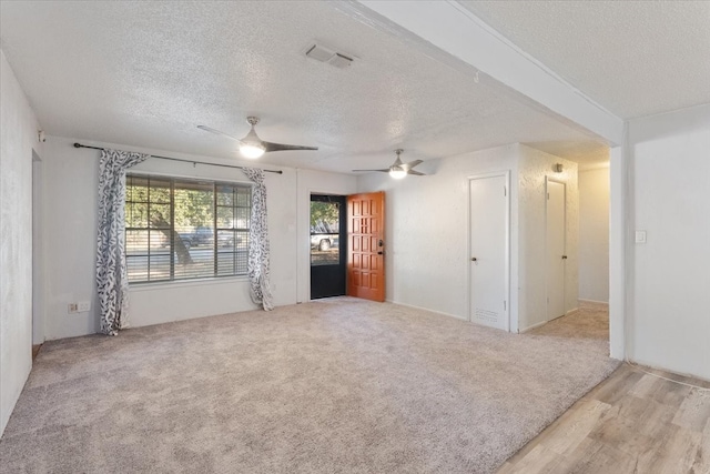 carpeted spare room featuring a textured ceiling and ceiling fan