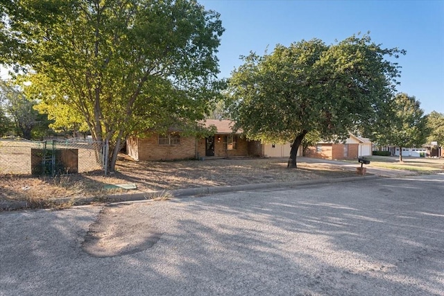 obstructed view of property with fence and driveway