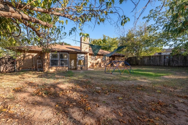 rear view of property featuring a lawn