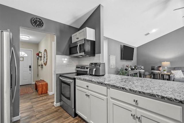 kitchen with backsplash, dark wood-type flooring, appliances with stainless steel finishes, and white cabinets