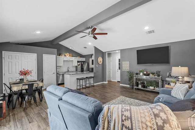 living room featuring dark wood-type flooring, ceiling fan, lofted ceiling with beams, and sink