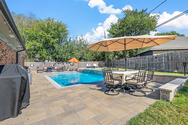 view of pool with pool water feature, a patio area, and a grill