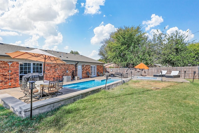 view of pool with a patio, central AC, and a yard