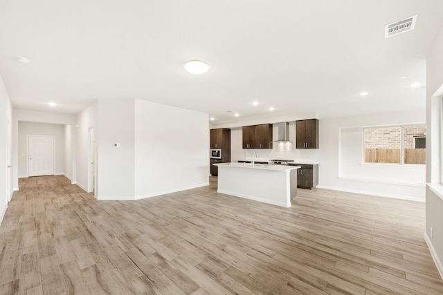 unfurnished living room featuring sink and light wood-type flooring