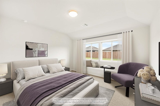 bedroom with light colored carpet and lofted ceiling