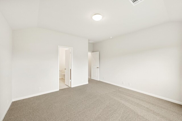 carpeted empty room featuring lofted ceiling