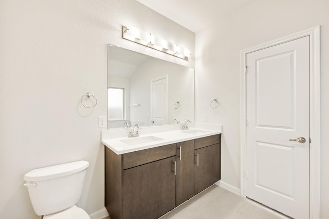 bathroom with tile patterned floors, vanity, toilet, and vaulted ceiling