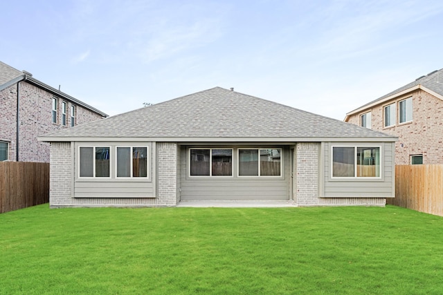 rear view of property featuring a lawn