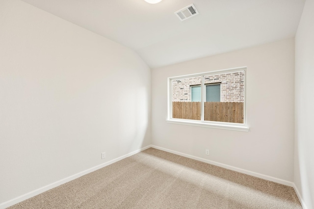 unfurnished room featuring carpet flooring and vaulted ceiling