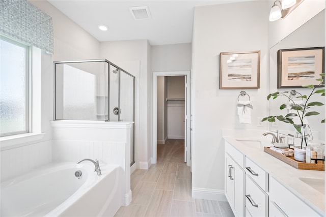 bathroom featuring vanity and independent shower and bath