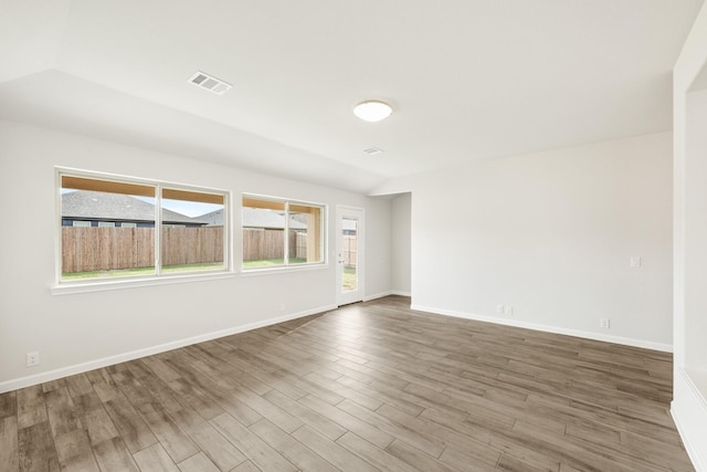 carpeted empty room with vaulted ceiling