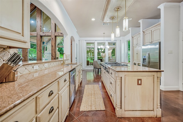 kitchen with light stone countertops, sink, a center island, and stainless steel appliances