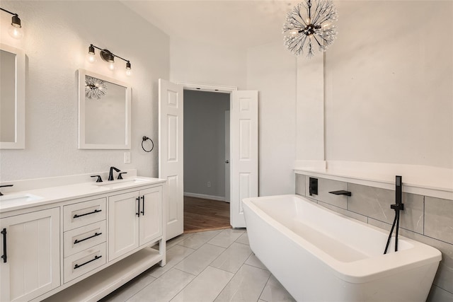 bathroom featuring vanity, a chandelier, a tub to relax in, and tile patterned flooring