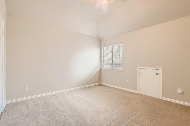 carpeted empty room featuring vaulted ceiling