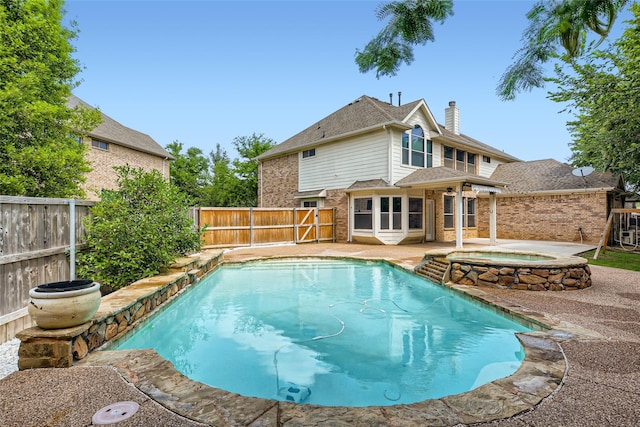 view of swimming pool featuring a patio and an in ground hot tub