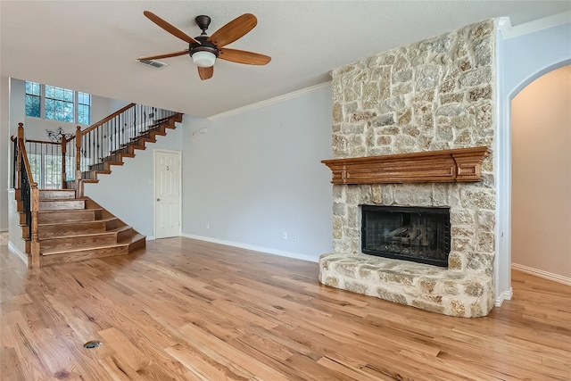 unfurnished living room featuring ornamental molding, light hardwood / wood-style flooring, a fireplace, and ceiling fan