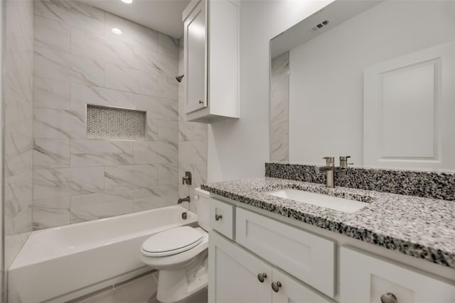 full bathroom with vanity, tiled shower / bath combo, and toilet