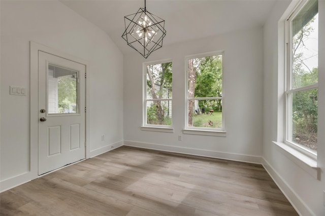 entryway with light hardwood / wood-style flooring, a notable chandelier, and lofted ceiling