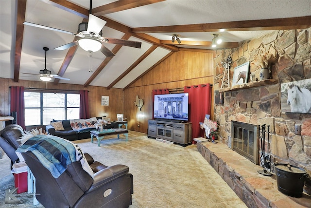 carpeted living room with a stone fireplace, wood walls, ceiling fan, and lofted ceiling with beams