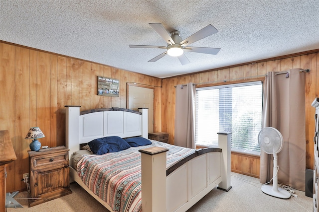 carpeted bedroom featuring ceiling fan, a textured ceiling, and wooden walls