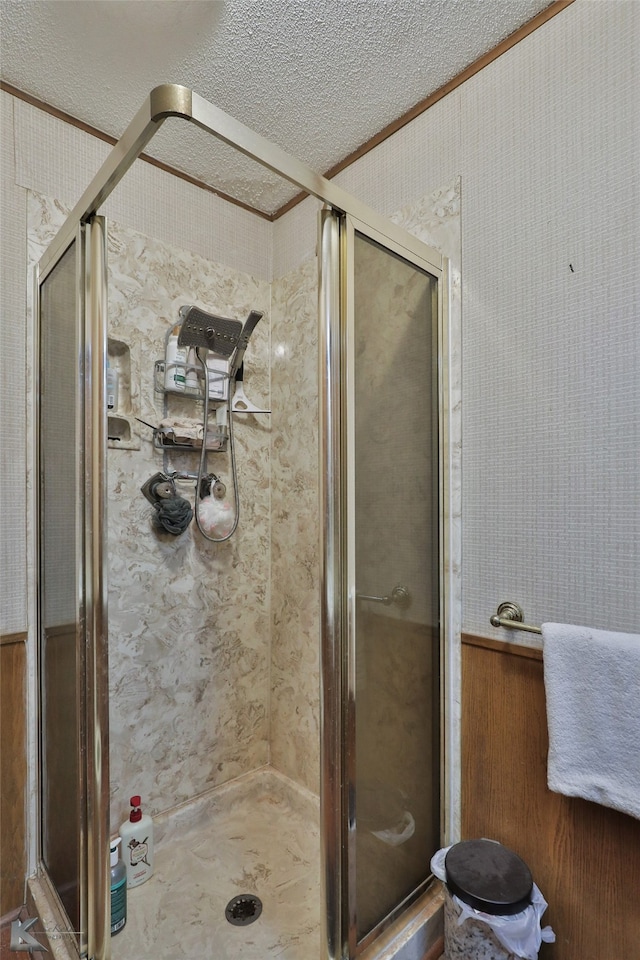 bathroom featuring an enclosed shower and a textured ceiling