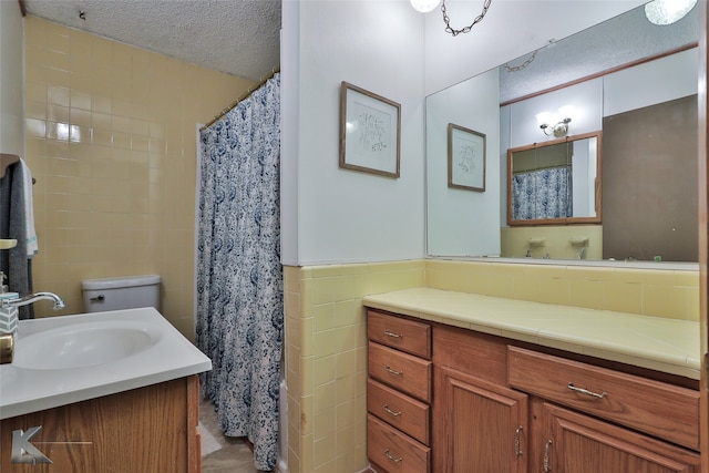 bathroom featuring vanity, a shower with shower curtain, toilet, a textured ceiling, and tile walls