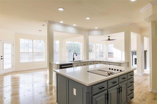 3004 Normandy Dr, Mckinney, TX 75070 - kitchen with a sink, gray cabinets, a kitchen island, stovetop with downdraft, and ornamental molding